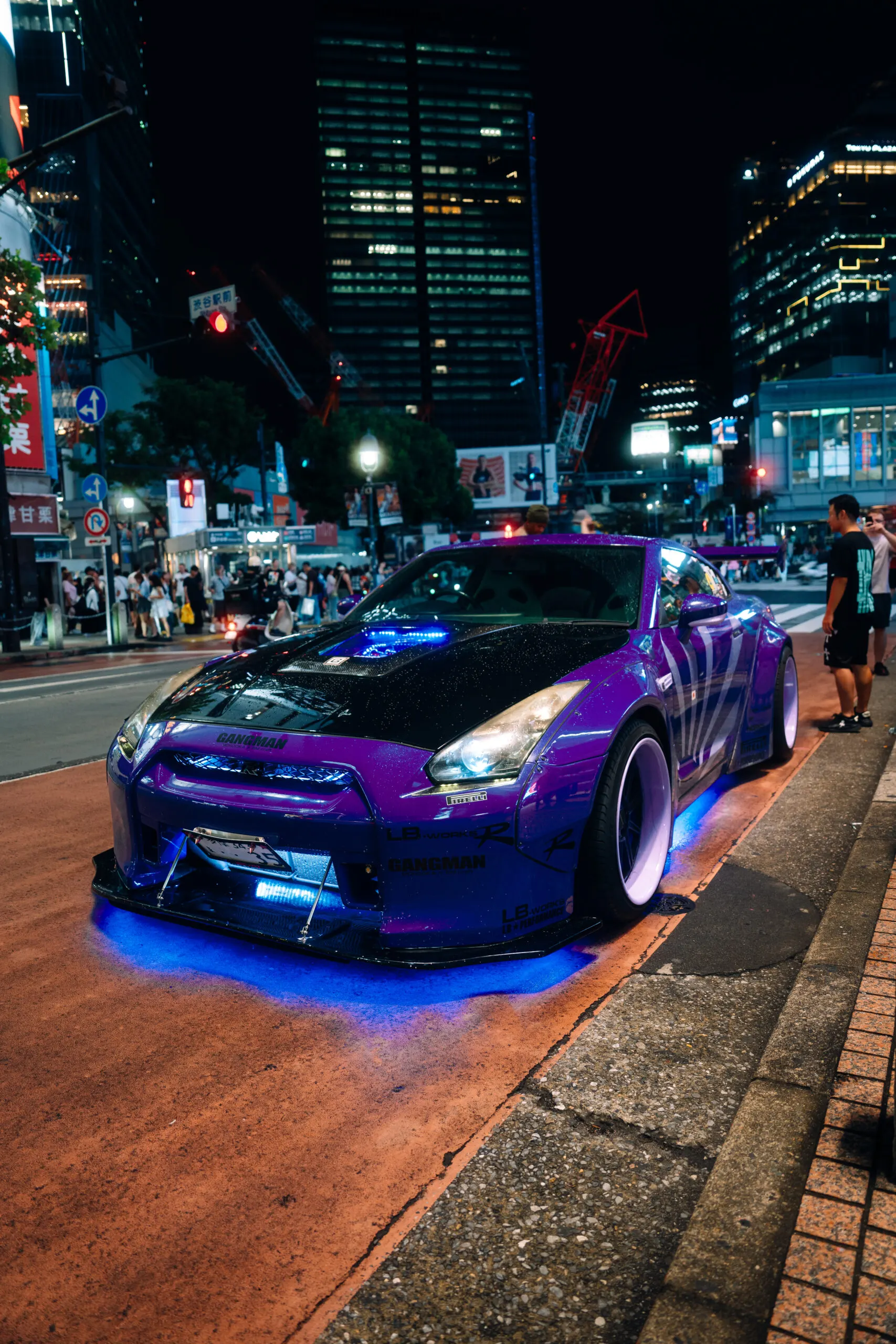 Purple Nissan GT-R with underglow on a Tokyo street at night