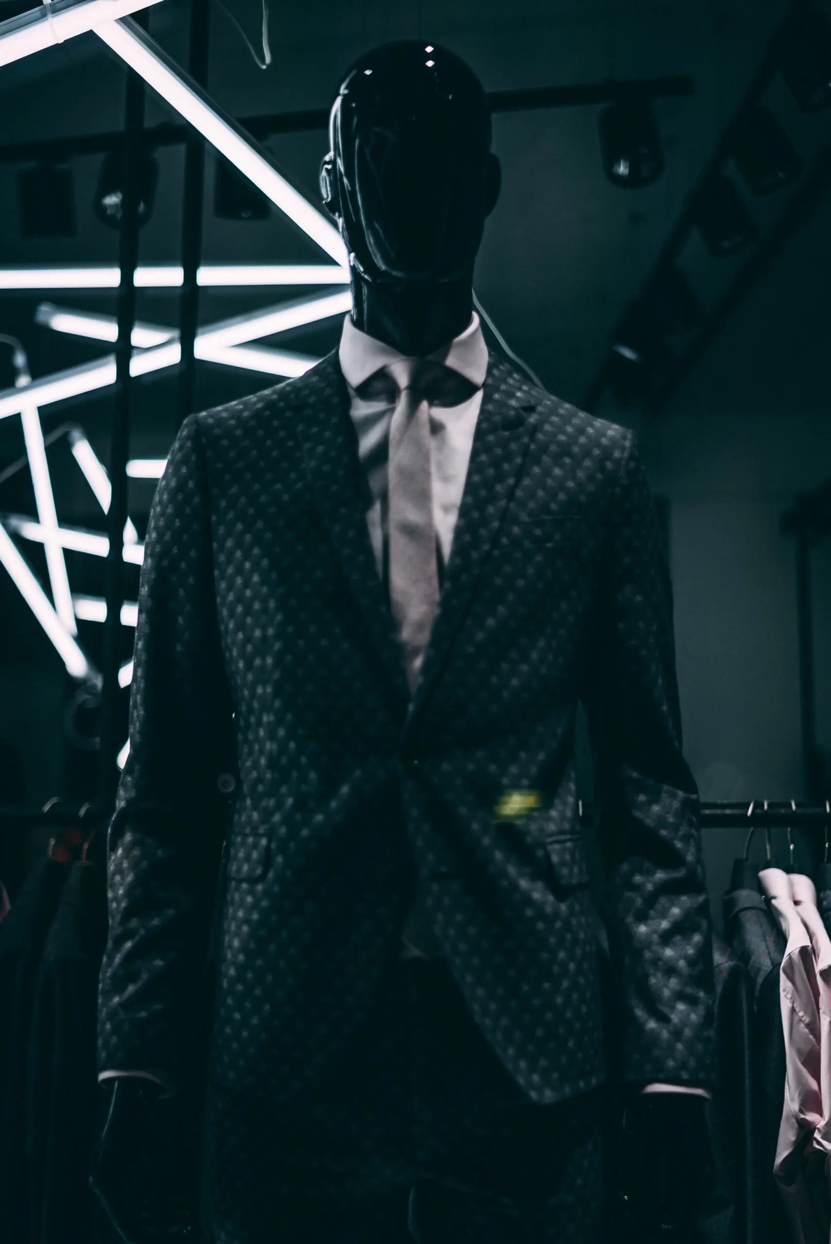Faceless mannequin in a dark suit in a shop window